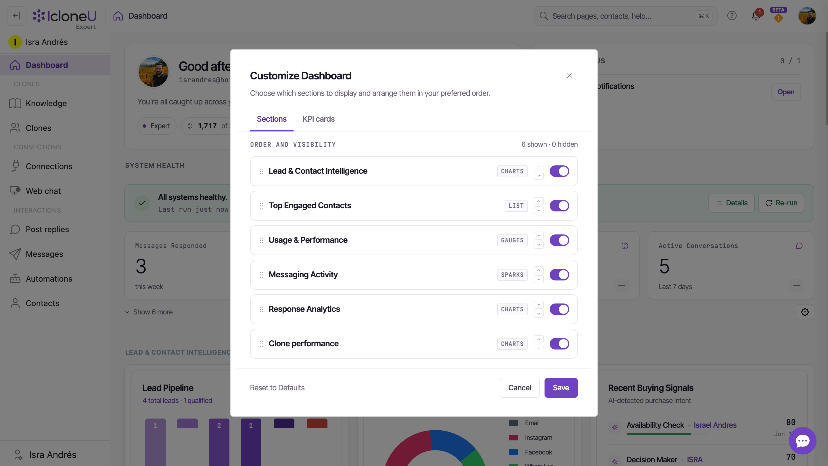 The Customize Dashboard modal showing the Sections and KPI cards sub-tabs with drag handles, toggles and the Reset to Defaults / Save controls